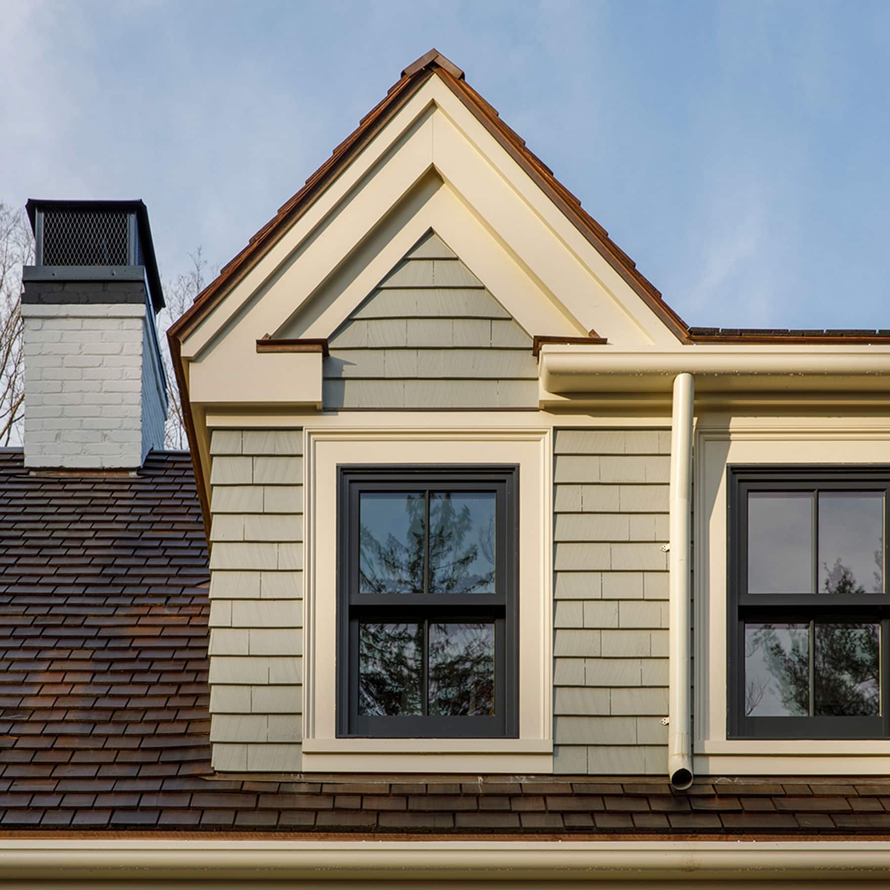 2nd-story window of green paneled house with chimney