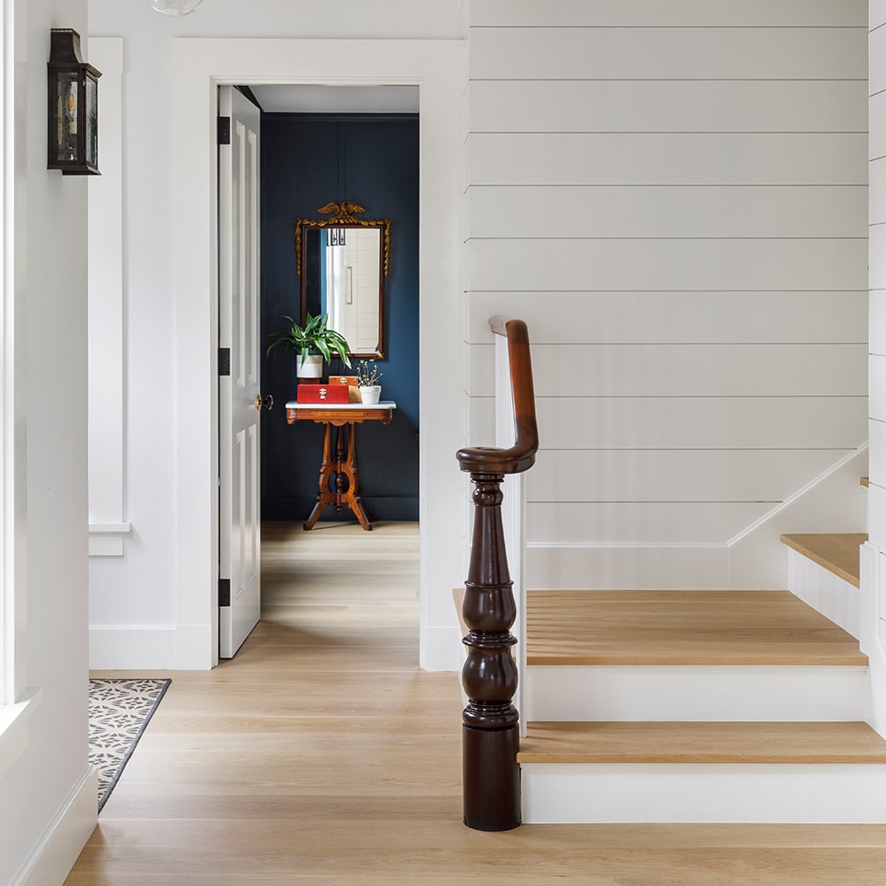 House foyer with white staircase and light wood floors